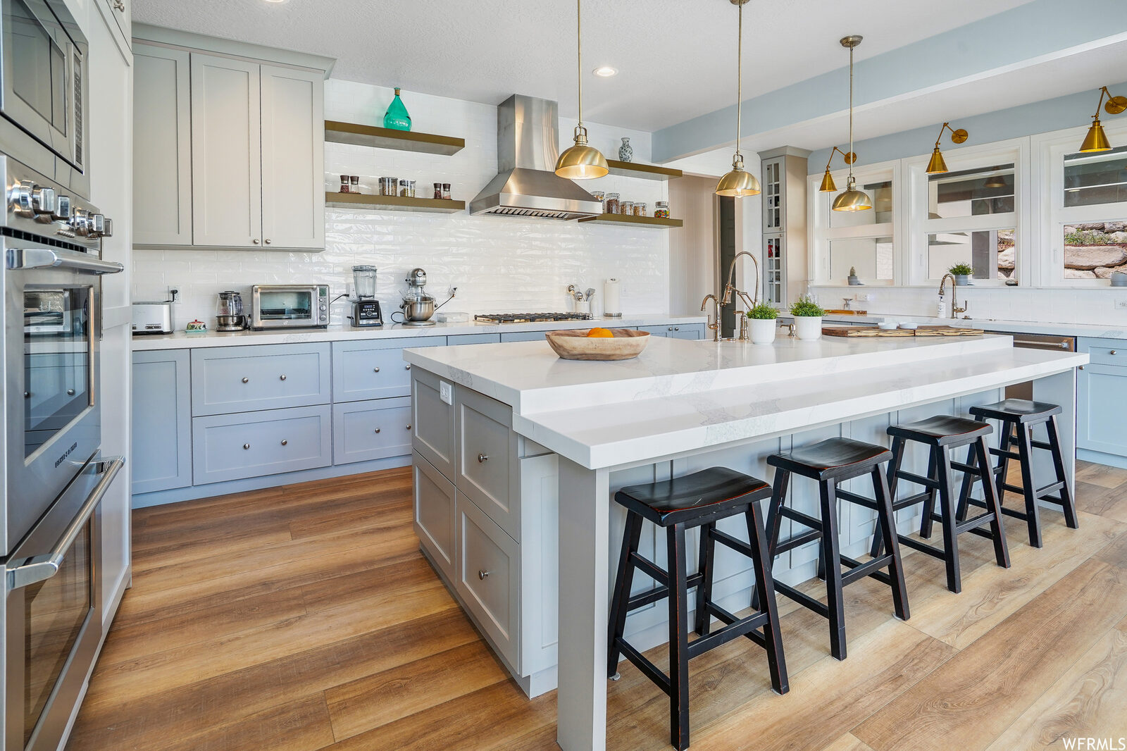 Kitchen with island seating and brass pendants